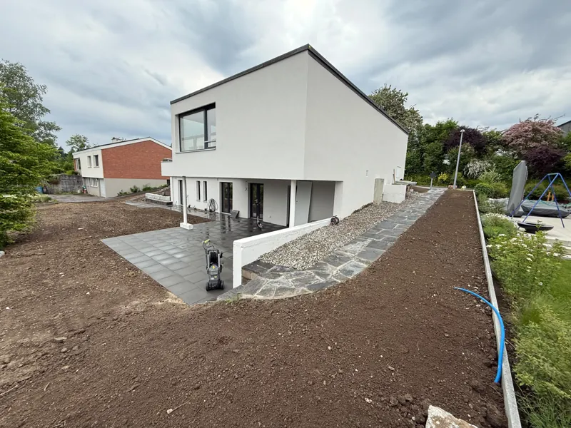 Dasselbe Haus während der Arbeit: Sitzplatz verlegt, Erde vorbereitet