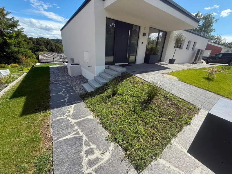 Hauszugang mit Polygonalplatten, Blockstufen und Rasen