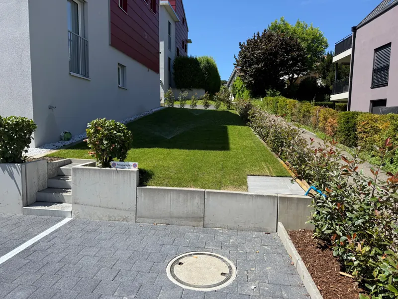 Treppe und Stützmauer aus Betonelementen, Pflästerung und Rasen
