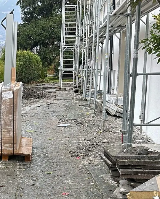 Vorher: alter Belag mit Bauschutt und Laub neben dem Baugerüst
